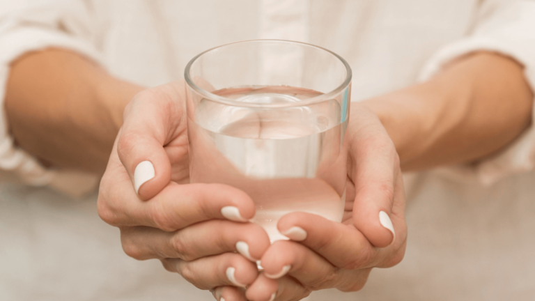 szklanka wody trzymana w dłoniach